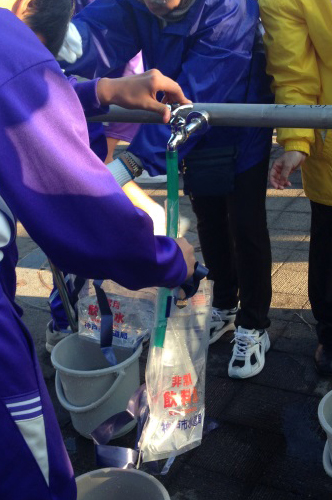 給水袋に水を入れる中学生の写真